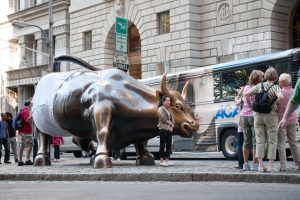 A photo of the Wall Street Bull in New Yorking wearing underwear while surrounded by a crowd.