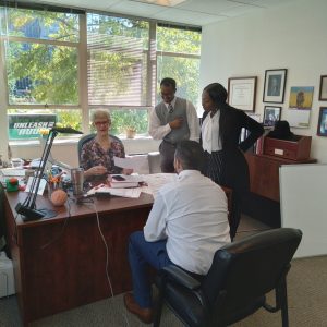 A phohograph of Dr. Emily Feistritzer in her office, along with members from Moreland University, a program preparing teachers online.
