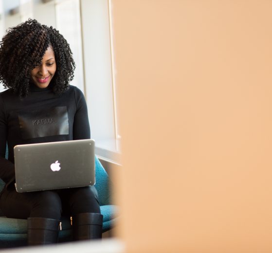 A photo of a woman using a laptop, representing the Women With Vision conference