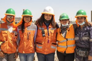 Five women at a construction site, wearing hard hats and orange vests--representing Atlas Renewable Energy, which won an award for gender diversity