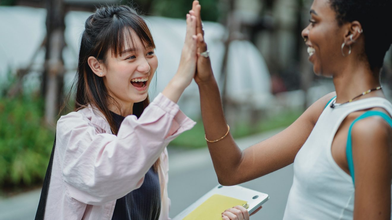 Two women high-fiving, representing the partnership for low income women