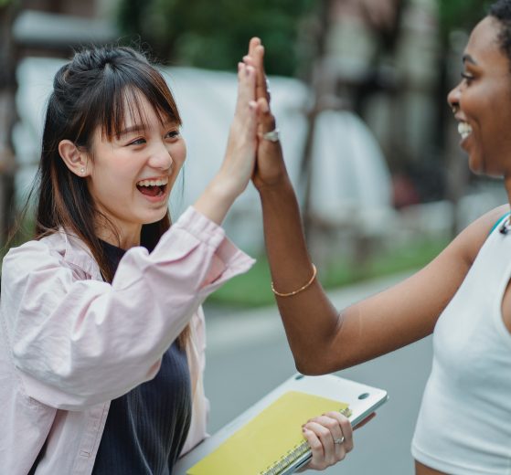 Two women high-fiving, representing the partnership for low income women