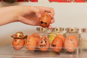 A carton of eggs with expressive faces drawn on