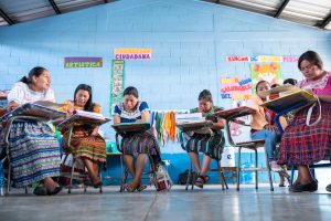 A group of women in Guatemala writing as part of Lancôme's literacy program