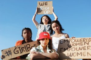 Four young women holding up women's empowerment signs
