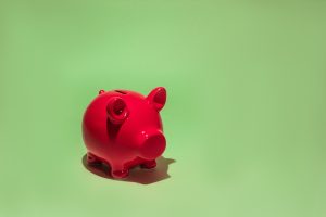 Pink piggy bank against a green background