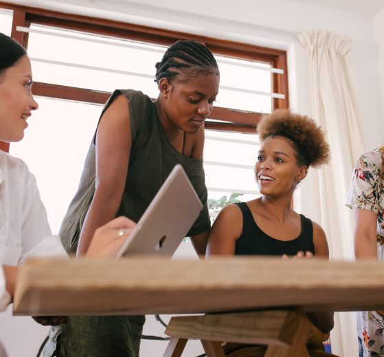 Four women working around a table, representing women's entrepreneurship