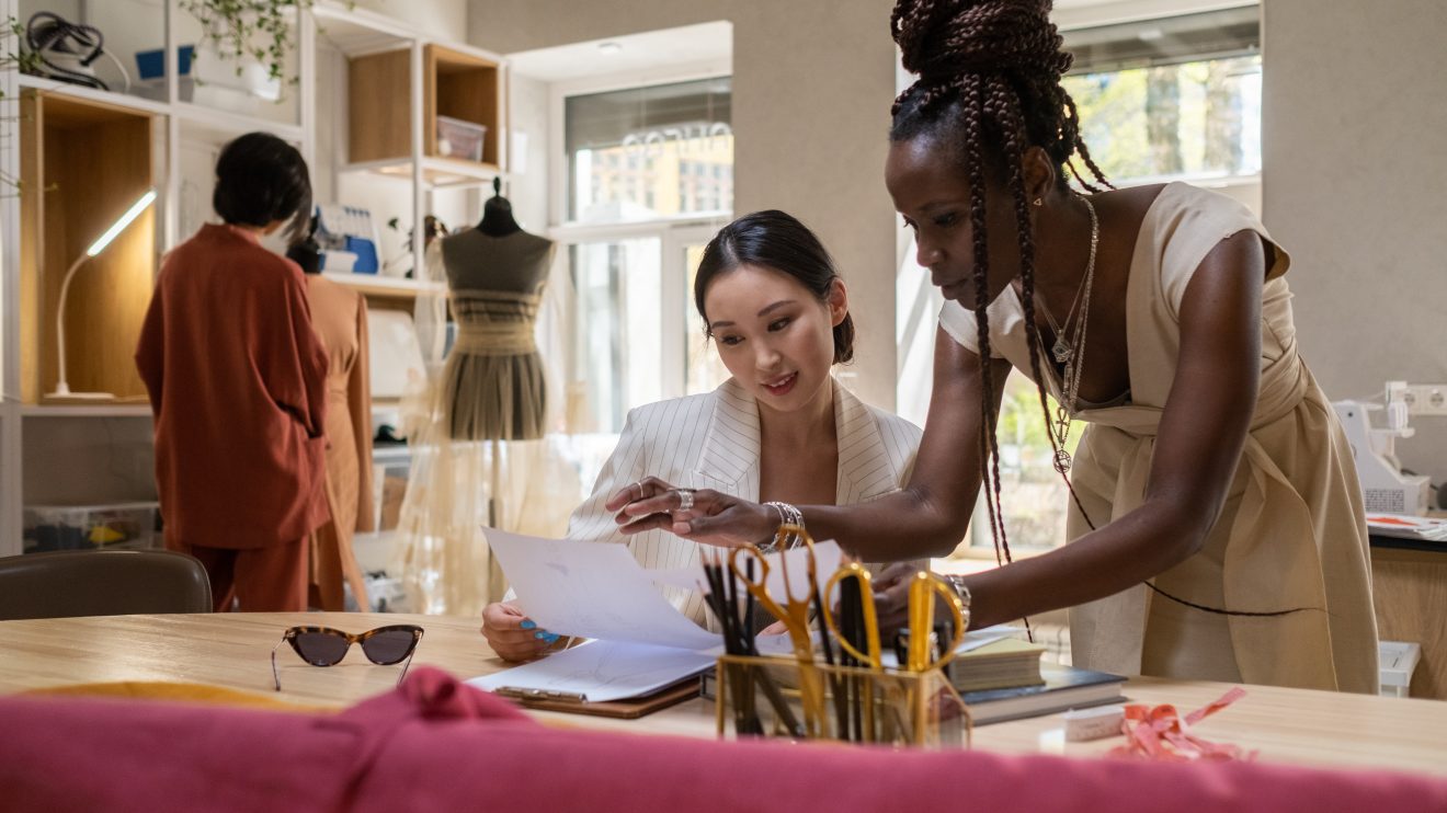Two women designing clothes in a studio, representing women of color entrepreneurs