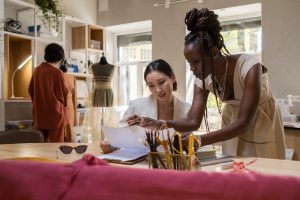 Two women designing clothes in a studio, representing women of color entrepreneurs