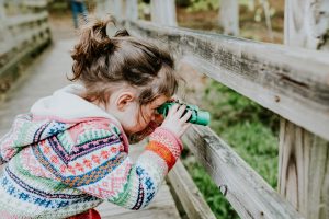 A photo of a young girl using binoculars, representing your business vision