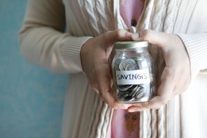 Woman holding a jar of savings, representing women planning retirement